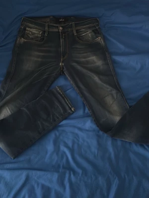 Mörkblå Replay jeans herr 31/32 - Säljer ett par mörkblå jeans från Replay med snygga slitningar och klassisk femficksmodell. Jeansen har smal passform och kontrastsömmar. Perfekta för dig som gillar en trendig och avslappnad stil. Enda defekten är det lilla hålet som jag tog bild på som är enkelt att sy igen:)