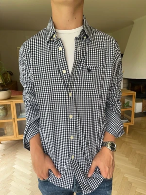 Abercrombie & Fitch skjorta rutig herr  - Snygg Abercrombie & Fitch skjorta i marinblått och vitt rutmönster 🤍💙 Klassisk modell med button-down krage, bröstficka och broderad älg-logga. Långa ärmar som enkelt kan vikas upp. Perfekt till jeans eller chinos. Fint skick! Passar både S/M  #Abercrombie #AbercrombieAndFitch #AandF #Skjorta #RutigSkjorta #Menswear #Preppy #Y2K #Vintage #Streetwear