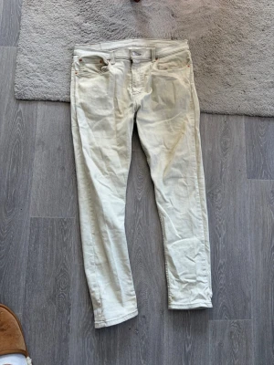 Vita/ljus blå Levi's 512 jeans - Säljer ett par väldigt ljusa Levi's 512 jeans med klassisk femficksdesign och raka ben. Jeansen har en snygg vintagekänsla och är tillverkade i ett slitstarkt bomullstyg. Perfekta för dig som gillar en clean och tidlös stil.