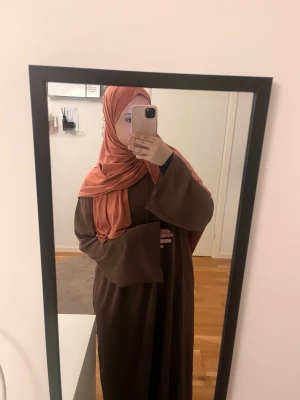 Abaya - Alniya - Säljer en vacker abaya i mustig rosa färg, med fickor. Den är i tunn material och går både att användas som en vanlig abaya men även underabaya. Jag är 158 cm lång och abayan når precis under mina fotled Storlek: 133 cm Material: Flytande medinasiden Användning: Endast en gång, i mycket bra skick
