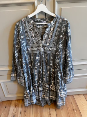Beautiful Juliet Dunn embroidered boho dress 🤍 - A stunning and unique dress in a gorgeous soft grey shade, covered in intricate white embroidery and mirror detailing. The floaty tiered silhouette and beautiful handcrafted-style details give it an effortlessly luxurious bohemian look.
