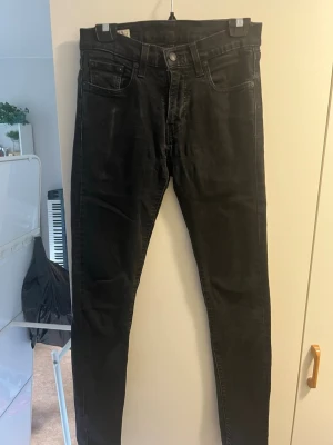 Svarta skinny jeans med hög midja - Säljer ett par svarta skinny jeans med hög midja och klassisk femficksdesign. Jeansen har smal passform hela vägen ner och är tillverkade i stretchigt denimtyg för extra komfort. Perfekta för en trendig och avslappnad stil.