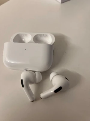 Trådlösa vita in-ear hörlurar - Säljer ett par stilrena trådlösa in-ear hörlurar i vit färg med laddningsetui. Hörlurarna har en modern, kompakt design med silikonproppar för bra passform och svarta detaljer på sidorna. Perfekta för musik, poddar och samtal på språng.