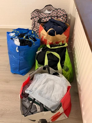 Stort klädpaket med blandade plagg - Säljer ett stort klädpaket med blandade plagg i olika färger och modeller. Innehåller bland annat skor, jeans, tröjor och t-shirts. Perfekt för dig som vill uppdatera garderoben med olika stilar och material. Plaggen kommer i flera olika färger och former. 1 påse 199kr/st och påsen med skor längst upp 399kr. Vill man ha alla påsar man vi diskuterar priset.