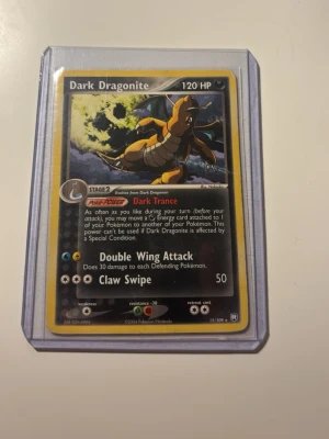 Pokémonkort Dark Dragonite - Säljer ett Pokémonkort, Dark Dragonite från Team Rocket Returns. Kortet har 120 HP och attacker som Double Wing Attack och Claw Swipe. Kortet är i plastficka och har en mörk design med guldkant. Perfekt för samlare eller Pokémonfans.