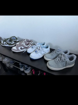 Nike sneakers i olika färger - Säljer flera par Nike sneakers i olika färger: grönt/vitt, beige/vitt, helvitt med blå detaljer och ljusgrått. Alla har klassisk låg siluett, snörning och tydlig swoosh på sidan. Perfekta för dig som gillar stilrena och sportiga skor. Det är 2 Nike dunk och 2 Nike airforce 1. Vid intresse skriv under denna annons så tar vi det därifrån. 1000kr vid köp av 2 par. Damskor.