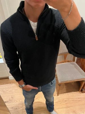 Svart halvzip-tröja från Pier One - Säljer denna mörka, stilrena stickade quarterzip från Pier One. Bra kvalité utan defekter. Storlek S.                          Axelbredd: 44cm. Övre axelsöm till ärmens slut: 63cm. Övre axelsöm ner till slut: 61cm. Skriv om du har en fråga!