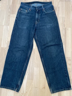 Levi's 578 blå raka jeans W30 L32 - Säljer ett par klassiska blå Levi's 575 jeans med raka ben och fem fickor. Jeansen har gul kontrastsöm, knappgylf och den ikoniska läderlappen bak i midjan. Tillverkade i slitstark denim, perfekta för en avslappnad och tidlös look. Fint skick, inga hål eller fläckar. Sparsamt använda. Nypris: Ca 1 100 kr. Säljer för att jag bytt stil