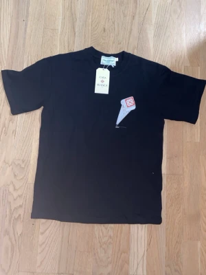 Casa Blanca t-shirt - Snygg svart t-shirt från Casa Blanca med unikt grafiskt tryck på bröstet och ryggen. T-shirten har klassisk passform och rund hals. Perfekt för dig som vill sticka ut med en cool design och samtidigt hålla det stilrent.