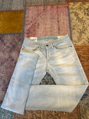 Ljusblå raka jeans från Dondup - Säljer ett par riktigt feta och eftertraktade Dundup jeans i modellen George, W30 som är helt perfekta nu inför skolstarten. Innerben-77cm, benöppning-15cm, midja-38cm. Tveka inte på att höra av dig vid frågor🙌