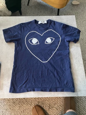 CDG T-shirt - Snygg t-shirt från Comme des Garçons i nästan nyskick. Passar perfekt som den är eller under en skjorta. Hör av dig vid funderingar :)