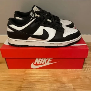 Nike Dunk Low panda  - Nike Dunk Low sneakers i svart och vitt läder med klassisk swoosh på sidan. Lågt skaft, svart yttersula och vita detaljer. Perfekt för dig som gillar stilrena och tidlösa sneakers med streetwear-vibe.
