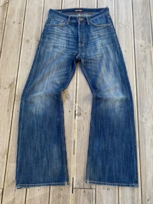 Marinblåa flared jeans med en sjuk wash! - Säljer ett par blå jeans med raka ben och snygga slitningar framtill och baktill. Jeansen har klassisk femficksdesign, normal midja och är gjorda i denim. Perfekta för en avslappnad och trendig look.