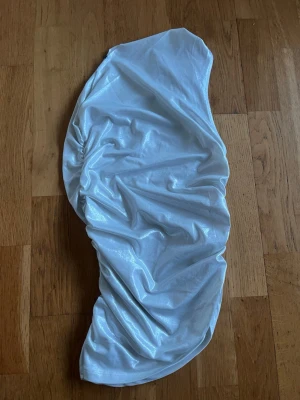 silvrig of shoulder topp  - Jag säger en tajt silver topp där det är of shoulder på ena axeln och den andra axeln är det ett linne. 