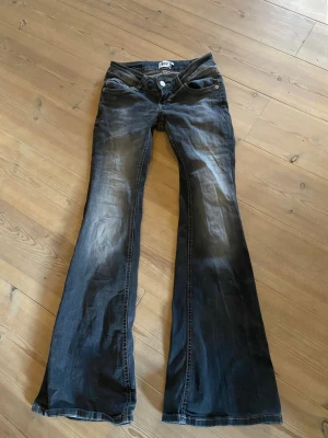 Grå svarta bootcut low Blaze  - Grå svarta bootcut Blaze jeans storlek xs från lager157