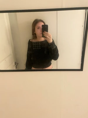 Svart croppad offshoulder topp - Säljer en svart croppad topp med offshoulder-design. Toppen har lång ärm och sitter snyggt på kroppen. Perfekt att styla med höga jeans eller kjol för en trendig look.