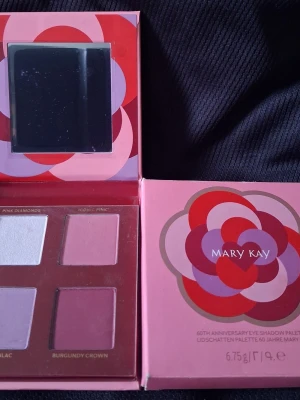 Mary Kay ögonskuggspalett 60 år - Snygg ögonskuggspalett från Mary Kay med fyra nyanser: vit (Pink Diamonds), ljusrosa (Iconic Pink), lila (Lilac) och vinröd (Burgundy Crown). Paletten har spegel och kommer i en rosa förpackning med grafiskt mönster.