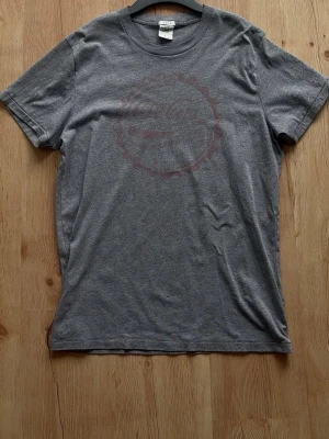Grå vintage Coca-Cola Abercrombie  - Vintage Abercrombie & Fitch med ett diskret Coca-Cola tryck i rött framtill. 