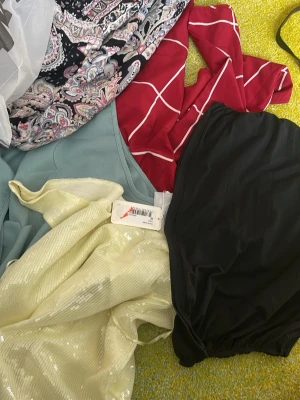Gul glittrig paljett-topp - Säljer en gul topp med glittriga paljetter och lätt transparent material. Toppen har en lös passform och är perfekt för dig som vill sticka ut. Passar till många olika stilar och är ett riktigt statement-plagg.