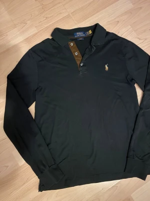 Svart långärmad henley från Polo Ralph Lauren - Klassisk o snygg svart långärmad pikétröja från Polo Ralph Lauren! Postar inom 24h📦 