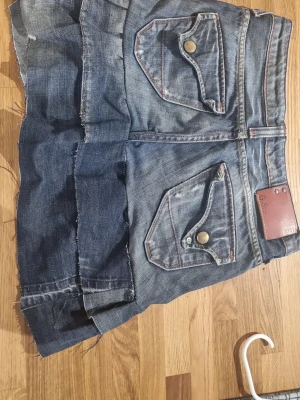 Jeanskjol med volang och fickor - Cool jeanskjol från G-star med volangdetalj och råa kanter. Den har en insydd tråd i midjan så man kan dra åt, passar xs till s eftersom att man kan dra åt och ha löst.     #baggyjeans #lowwaist jeans #cargobyxor #vida jeans #flarejeans #lågmidja #rakajeans #kostymbyxor #mjukisbyxor #oversizedhoodie #ziphoodie #stickadtröja #corsettopp #offshoulder #babytee #linne med spets #oversized tshirt #stickadväst #maxikjol #y2k #vintage #streetwear #oldmoney #cleangirl #basic #festkläder #vardagskläder #