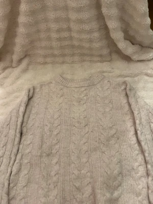 Ljusbeige kabelstickad tröja XS - Mysig ljusbeige kabelstickad tröja i klassisk modell med rund halsringning och ribbade muddar. Tröjan har ett tidlöst flätmönster och är perfekt för lager på lager under kyliga dagar. Passar dig som gillar enkel och stilren stickad design.
