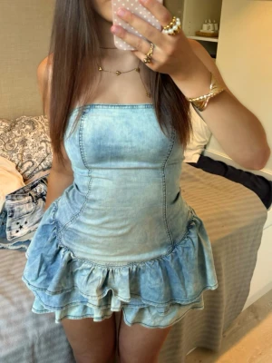 Vintage Denim volangklänning  - Såå fin vintage axelbandslös volangklänning i denim! Längd: 63 midja rakt över: 33 byst rakt över: 36. Jag är 168 och det är mina bilder, köp via köp nu direkt eller Swish, kvar tills markerad som såld 💖 