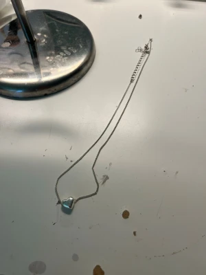 Silverhalsband med hjärthänge - Snyggt halsband i silverfärg med ett hjärtformat hänge. Kedjan är tunn och stilren, perfekt för dig som gillar minimalistiska smycken. Hjärtat ger en söt touch och passar till många olika looks.