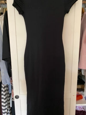 Svart långklänning från Bershka - En svart långklänning från Bershka med korta ärmar. Tillverkad i mjukt och stretchigt material för en bekväm passform. Passar storlek xs/s💕