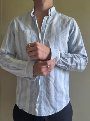 Blå/vit randig skjorta från Zara - En riktigt schysst blå/vit randig skjorta från Zara. Som ny. Storlek L, men sitter som M. Personen är 181cm och 80kg. Hör av er vid mått eller andra funderingar. Skickas inom 24h.