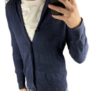 Pedro Del Hierro - Mörkblå stickad kofta med sjalkrage och diskret strukturmönster. Koftan har en knapp framtill och långa ärmar. Perfekt att slänga över en t-shirt för en chill look. 