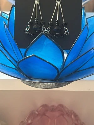Svarta Handgjorda Chandelier örhängen med droppformade detaljer -  Handgjorda chandelier örhängen med  droppformade detaljer med svarta pärlor Hängande design med tunna metallstavar som ger en cool och elegant look. Perfekta för dig som vill sticka ut med accessoarer som känns både trendiga och personliga.