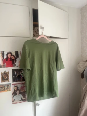Grön oversized t-shirt - Säljer en enkel grön oversized t-shirt med rund halsringning och korta ärmar. Perfekt för en avslappnad och stilren look. Tillverkad i mjuk bomull som känns skön mot huden. Storleken är S men eftersom det är oversize skulle jag mer beskriva den som L! Superbra kvalité och knappt använd!