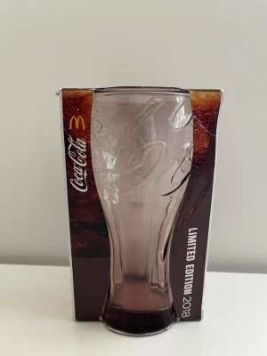Coca-Cola glas McDonald's 2018 Limited Edition - Helt nytt Coca-Cola-glas från McDonald's Limited Edition 2018. Glaset är i nyskick och ligger kvar i sin oöppnade originalförpackning.    McDonalds Coca Cola Cocacola kopp mugg dricka dricksglas dricks