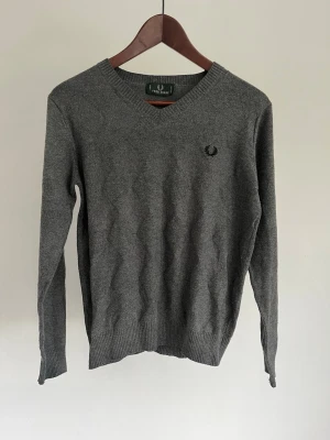 Fred Perry finstickad v-ringad tröja - Fred Perry finstickad v-ringad tröja Storlek: XS Passform: Slim Fit Krage: V-ringat (V-neck) Material: Bomull Skick: Tröjan är i ett väldigt fint skick utan defekter  Nypris cirka: 1 000 kr