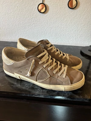 Phillipe Model Skor - Säljer dessa snygga och väldigt eftertraktade sneakers från Phillipe Model! Skorna är i materialet mocka i sen stilren grå färg. 100% Äkta, köpta för ca 2 år sedan för ish 4000kr. Har satt dit en annan innersula då orginalsulan blivit sliten pga användning, se bild 2. Finns även ett mindre hål på bakre undersida av skon men inget som jag tycker känns när man går med dem, se bild 3. Skorna är alltså ganska använda därav priset. Orginalbox och dustbag ingår! Tveka inte på att skriva vid frågor💯
