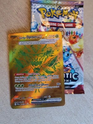 Pokémon booster och Ogerpon EX-kort - Säljer ett Pokémon booster pack från Scarlet & Violet-serien samt ett holografiskt Ogerpon EX-kort. Kortet har en skimrande guldfärgad yta och coolt mönster. Perfekt för samlare eller dig som vill boosta din lek med ett kraftfullt kort.