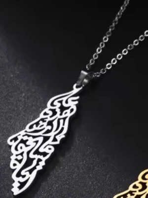 Palestina karta Silverfärgat halsband med arabisk text - Unikt halsband i silverfärg med ett hängsmycke format som arabisk kalligrafi. Kedjan är tunn och har små, runda länkar. Perfekt för dig som gillar personliga och stilrena accessoarer med en kulturell touch.