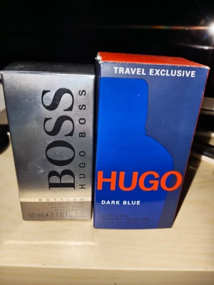 Hugo Boss Bottled (50ml) & Dark Blue (75ml) - Klassiska herrparfymer -  ​Hugo Boss - Bottled EdT (50 ml): Endast testsprayad/sparsamt använd, i stort sett full flaska. Äldre batch ("P&G Prestige Beauté") som är känd för riktigt bra hållbarhet och doftprofil. Kommer med originalkartong. ​Hugo Boss - Dark Blue EdT (75 ml): Endast testsprayad/sparsamt använd, i stort sett full flaska. "Travel Exclusive"-utgåva med originalkartong