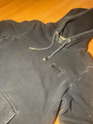 Mörkgrå hoodie från Superdry - Säljer nu min hoodie från superdry med en fet tvätt / skick 8,5/10 avgörs på bilderna / storlek S / kontakta mig via intresse eller annat och priset kan självklart diskuteras😊