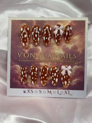 Bambi 🎀(XS);Medium Almond - Snygga handgjorda press-on naglar i brun färg med vita Bambi fläckar och söta ljusrosa rosetter. Naglarna har en medium lång almondform och är perfekta för dig som vill sticka ut. XS: 14 mm, 11 mm, 11,5 mm, 10 mm, 8 mm och designen är inspirerad av Bambi.