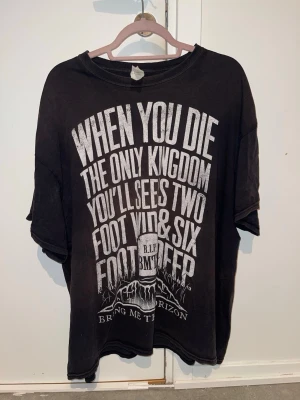 Svart Bring Me The Horizon t-shirt - Cool svart t-shirt med stort vitt tryck fram från Bring Me The Horizon. Oversized passform och klassisk rund hals. Väl använd!