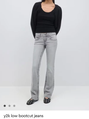 Gråa lowrise bootcut jeans - Säljer ett par ljusgrå jeans med låg midja och bootcut passform, perfekta för en Y2K-inspirerad look. Materialet är denim med lätt stretch för skön passform. Fickorna på baksidan fungerar