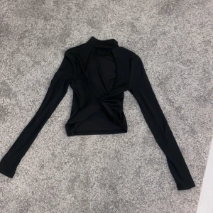 Tröja  - Hej! Säljer dina svarta långärmade tröja med hål i ryggen på grund av att den inte kommer till användning!! Fint skick förutom att den är nopprig om armarna