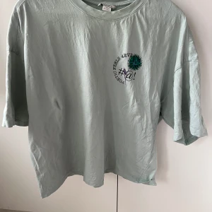 Mintgrön croppad t-shirt - En mintgrön croppad boxy t-shirt från Monki. Lite oversize i storleken. Använd men fortfarande i fint skick. 