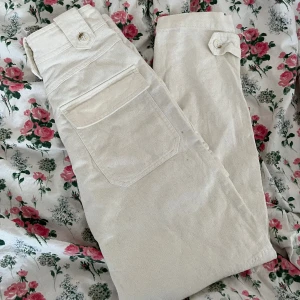 Vita cargos - Ett par crémevita cargobyxor i bomull med hög midja och fickor framtill samt baktill från H&M i strl 32!💓  Skriv för mer bilder och info!🌟