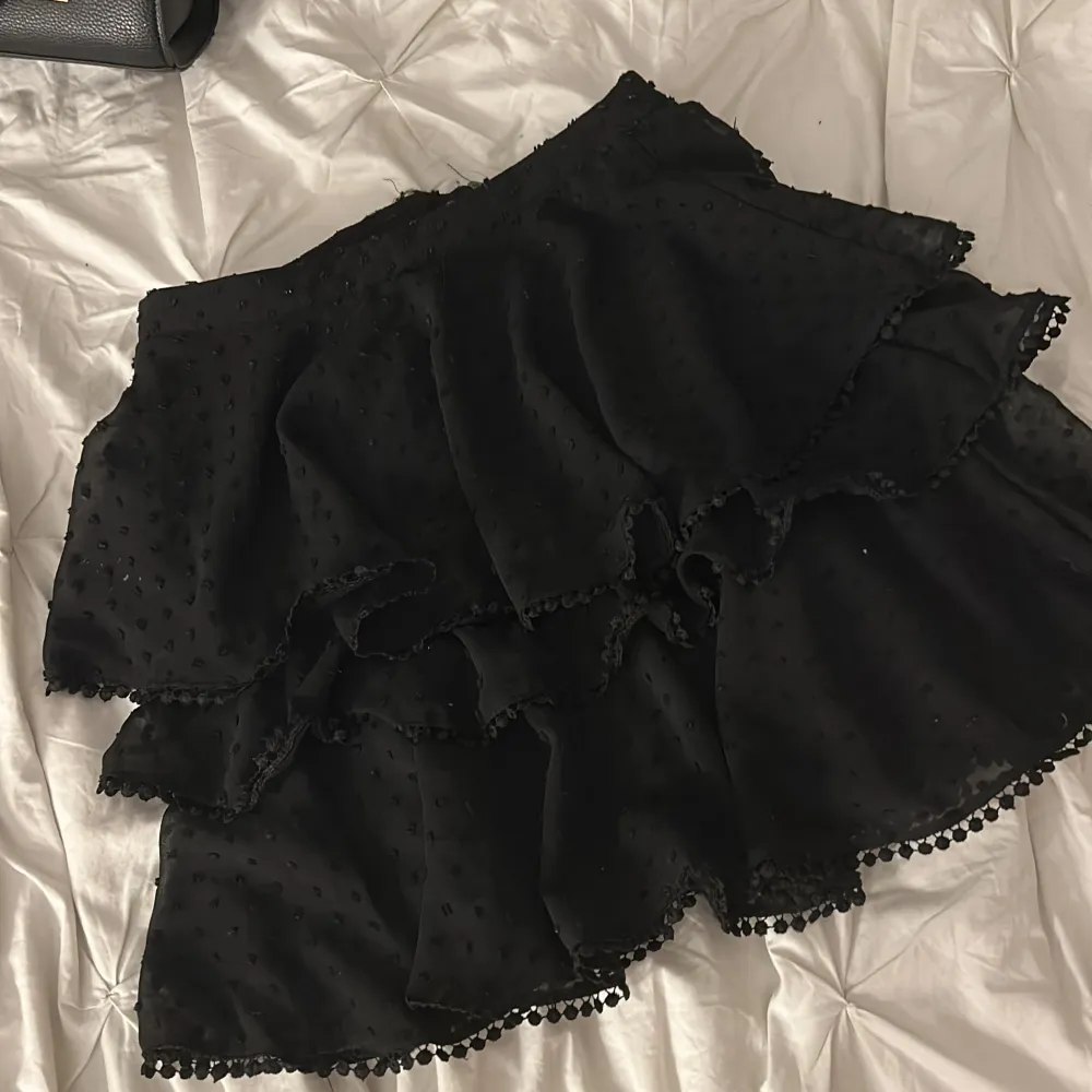 En svart gullig volang kjol med prickar på, den har ett till lager under volangerna så väldigt säker kjol. Väldigt bra skick och har inte alls använts mycket . . Kjolar.