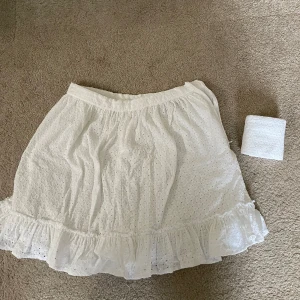 Vit kjol - En vit kjol med volang. Det finns ett skärp till kjolen men måste inte användas. Mycket bra skick😊