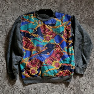 Grå tröja med kedja - Köpt secondhand. Okänt märke. Lagom varm. Mjuk. Grå baksida. Kul mönster. Guldig. Myströja. Fluffig. St 36. St 38. Pris 70kr. Möts i gbg 