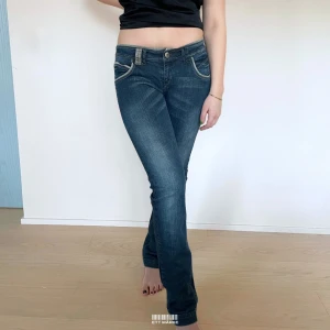 Lågmidjade Vintage Bootcut Jeans  - Mer info och möjligheten att köpa plagget hittar du på vår hemsida😊  MODELL: Lågmidjade & Bootcut. FÄRG: Mörkblå. STORLEK: 38 enligt lapp. Uppskattad storlek 36. MIDJA RAKT ÖVER: 38 cm. MIDJEHÖJD: 20 cm. TOTALLÄNGD (FRÅN MIDJAN): 108 cm